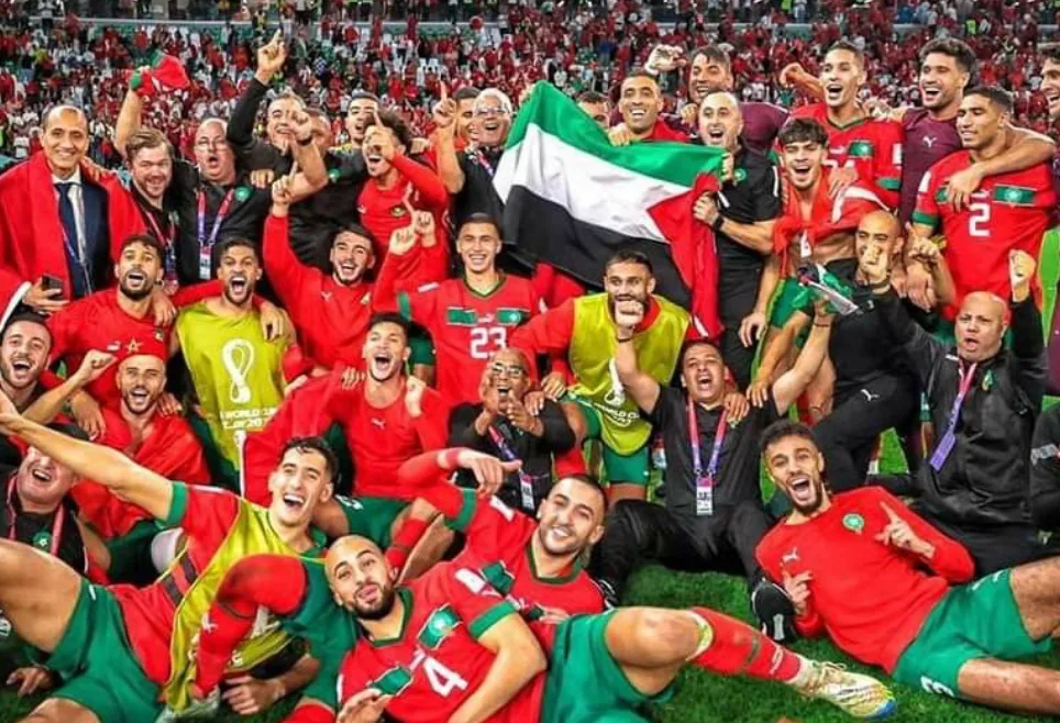 Joueurs du Maroc en maillots rouges célébrant avec un drapeau – maillots du Maghreb